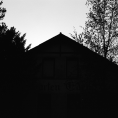 Schwarzweiß-Film-Foto eines leerstehenden Hauses mit der Aufschrift „Garten Eden“