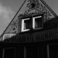 Schwarzweiß-Film-Foto eines bemalten Hauses mit der Aufschrift „Das verzauberte Hexenhaus“