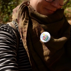 Selfie mit Fokus auf den Button am Halstuch, der einen l&auml;chelnden Zug mit den Worten &bdquo;B&auml;derbahn auch nach 2030 erhalten&ldquo; zeigt