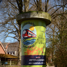 Litfa&szlig;s&auml;ule mit riesigem Banner der Kampagne f&uuml;r den Erhalt der B&auml;derbahn