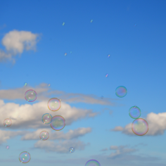 Seifenblasen vor blauem himmel mit Wolken